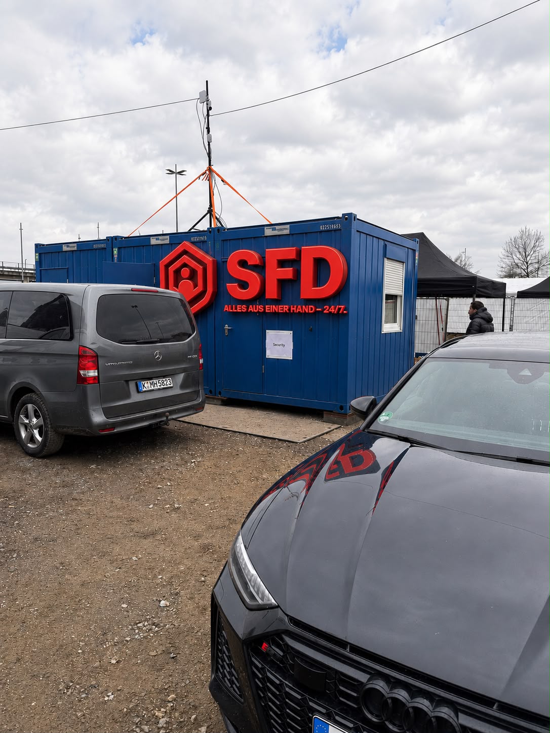 SFD-Dienstleistung24 Bürocontainer mit Logo und Firmenfahrzeugen auf dem Betriebshof in NRW